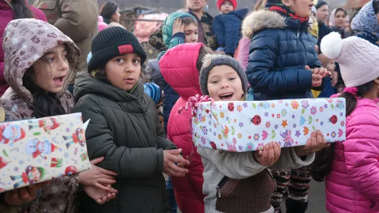 Kinder empfangen voll Freude ein Weihnachtspäckli